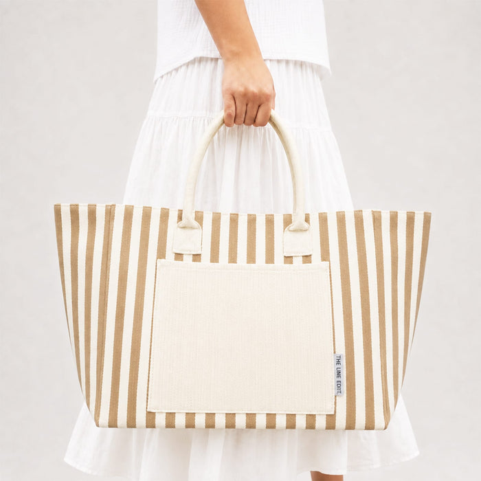 Hampton Tote Bag by The Line Edit. - A striped tote bag in beige and cream, featuring a large front pocket and sturdy handles.