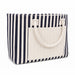 Hampton Tote Bag by The Line Edit. - A striped tote bag featuring navy and white stripes with a solid cream front pocket and two handles.