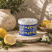 Bloom Fragrance Pot - A blue fragrance pot with a lemon pattern, surrounded by fresh lemons and greenery on a textured surface.