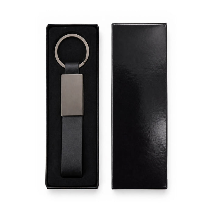 Zander Keytag - A black keytag with a sleek silver ring and rectangular pendant, displayed in a black box.