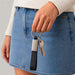 Zander Keytag - A woman is holding a black and silver keytag with keys attached, wearing a denim skirt and a light sweater.