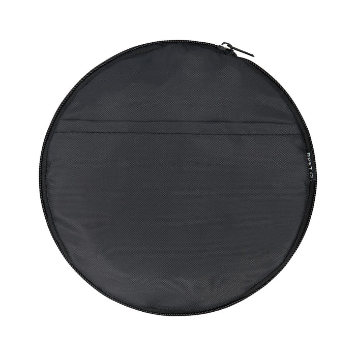 The Escape Pack - A round black duffle bag with a zip closure and a flat pocket on one side. It features a logo.