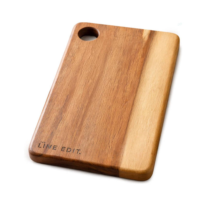 The Line Edit Acacia Serving Board - An acacia serving board featuring a natural wood finish with a circular handle and engraved branding.