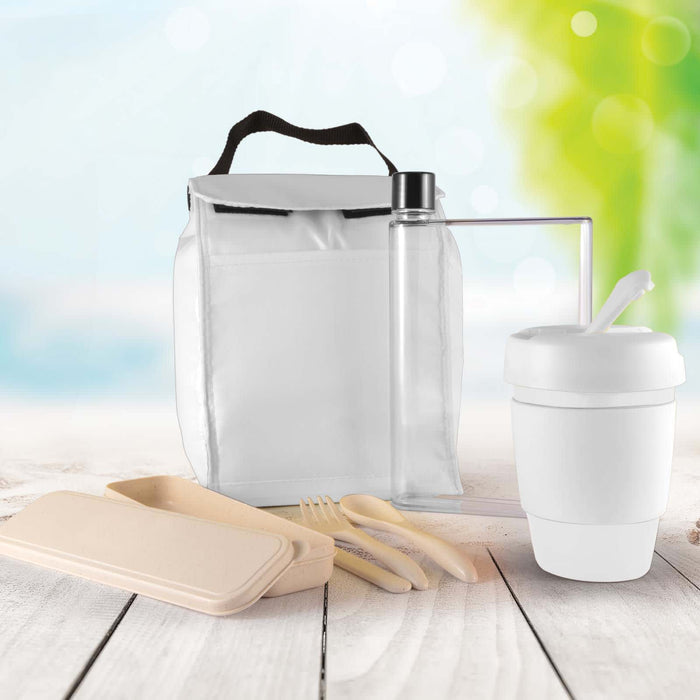Picnic Pack - A white picnic pack with a drink bottle, a reusable cup, and eco-friendly utensils, set against a blurred outdoor background.