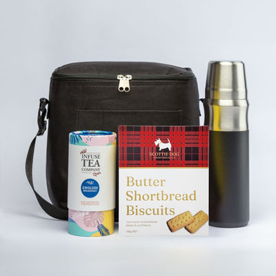 The Brew & Bite - A cooler bag in black, a silver drink bottle, a tin of tea, and a box of butter shortbread biscuits.