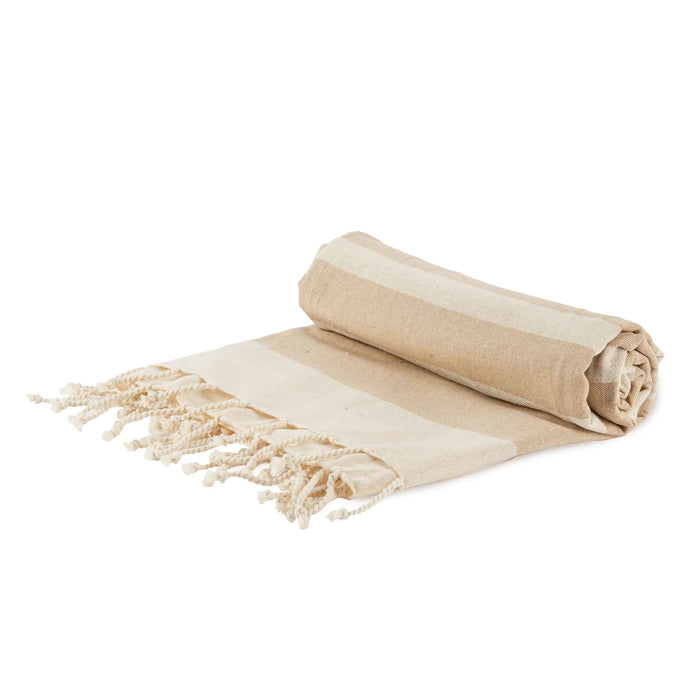 The Weekend Edit - A rolled beige and cream striped picnic blanket with fringed edges, featuring a simple design. It has a logo.