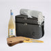 The Sunset Pour - A drink bottle, picnic blanket, wooden cutting board with knife, and a grey cooler bag. The drink bottle is white.