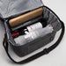 The Sunset Pour - A drink bottle cooler bag in grey containing a bottle of wine, a rolling pin, and a rolled-up blanket.