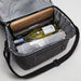 The Sunset Pour - A drink bottle and a blanket inside a grey cooler bag, with a wooden board on top and a black box.