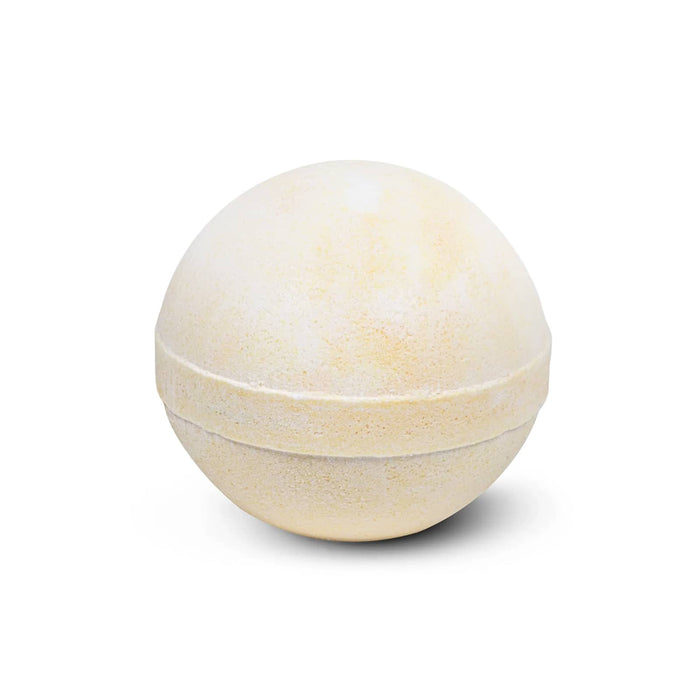 The Cosy Indulgence - A bath bomb in a spherical shape, featuring a pale yellow hue with a smooth texture. It has a simple design.