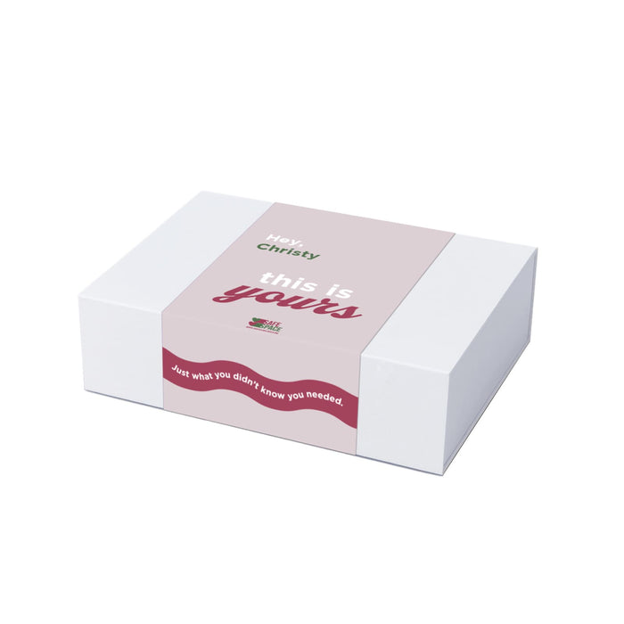 The Mindful Moment - A white gift box with a pink and green label featuring a message and a decorative wavy design.