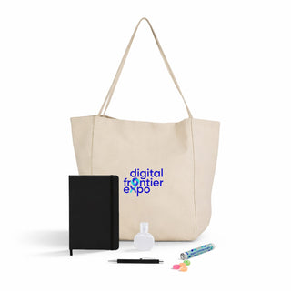 Expo Essentials Pack - A beige tote bag contains a black notebook, a drink bottle, a pen, and colourful candies. It features a logo.