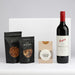 The Perfect Pairing - A drink bottle of red wine accompanied by packets of salted nuts, pretzels, and caramel fudge. All items are elegantly arranged.
