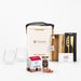 The Festive Edit Gift Set - A festive gift set featuring two glass tumblers, a wine cooler, a wooden board, a knife, and Christmas-themed treats.