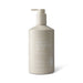 The Coastal Edit - A hand and body wash in a beige pump bottle with a logo, featuring sea salt and pearl extract.