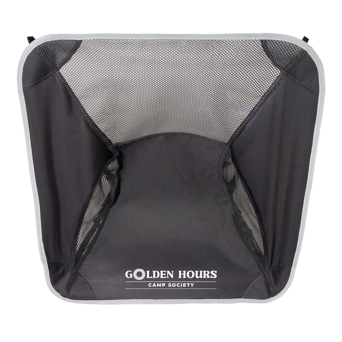 The Escape Pack - A mesh camping chair in black with a grey trim and a logo at the bottom.