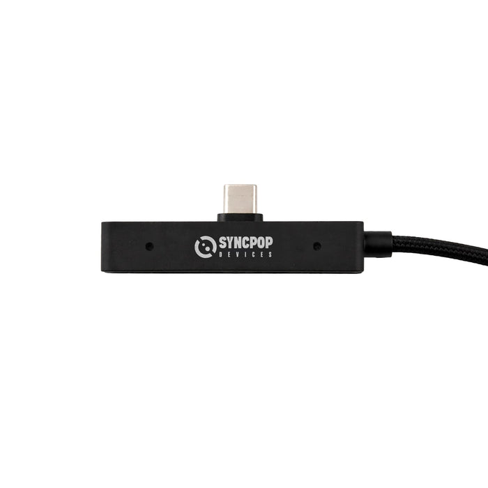 Tech Pack Charge - A black charging dock with a USB-C connector, featuring a logo and attached cable.