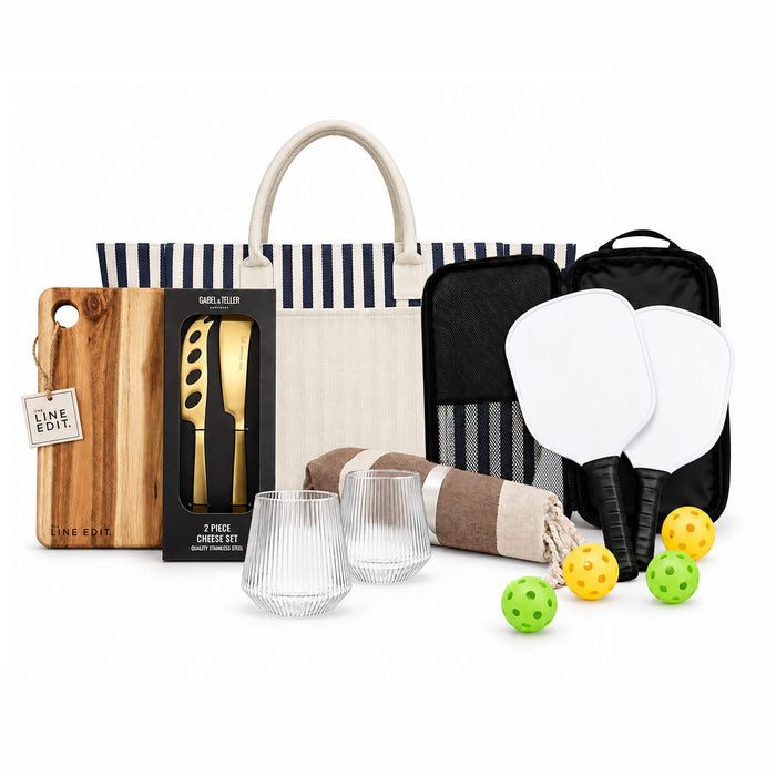 The Play & Graze - A tote bag with navy stripes, a cheese knife set, glass tumblers, paddles, and colourful balls.