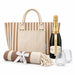 The Sun & Sip Gift Set - A striped tote bag, a bottle of champagne, two glasses, and a rolled blanket with a ribbon.