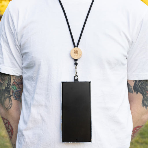 Shadow Phone Neck Lanyard - A phone neck lanyard featuring a wooden clip and a black strap, securely holding a smartphone.