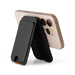 Cozy Phone Wallet - A black phone wallet stands upright against a smartphone, showcasing its sleek design and functionality.
