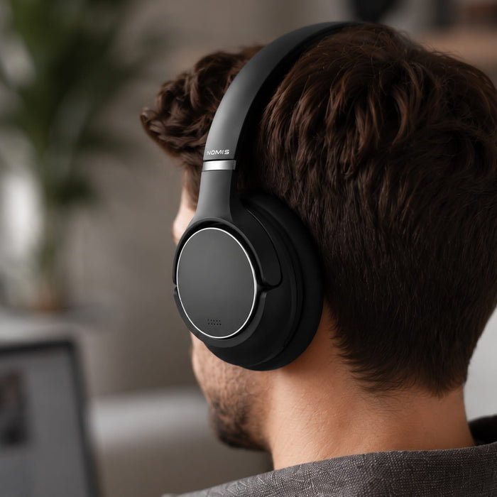 Aero by Nomis Headphones - Black wireless headphones with a sleek design being worn by a person, featuring a subtle logo.