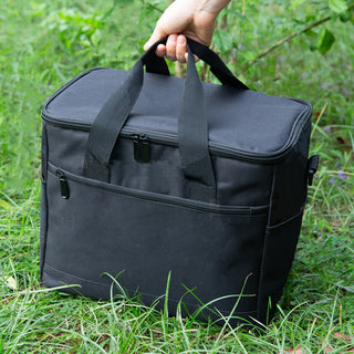 Large Nylon Cooler Bag - A black nylon cooler bag with carrying handles and a front pocket, positioned on green grass.