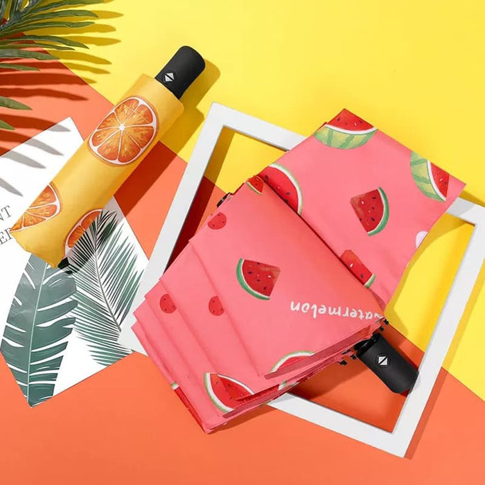 Full Colour Poppins Umbrella - A pink umbrella featuring watermelon and orange patterns, with a curved black handle and a logo.