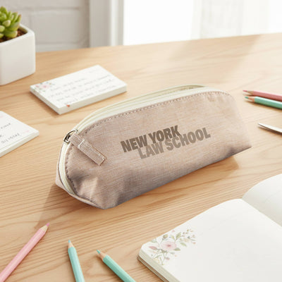 Penca RPET Pencil Case - A beige pencil case with a zip closure sits on a wooden desk among stationery and notepads. It features a logo.