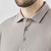 Men's Nevada L/S Micro Pique Polo - A men's long-sleeve polo shirt in a muted grey shade featuring a collar and button details. It includes a logo on the chest.