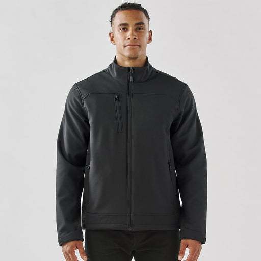 Men's Aleutian Softshell Jacket - A men's softshell jacket in black, featuring a front zip and a branded logo on the chest.