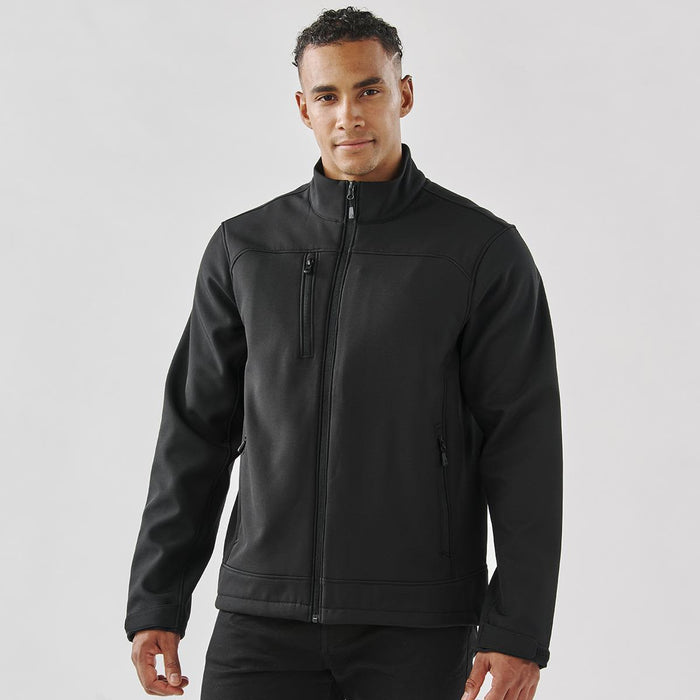 Men's Aleutian Softshell Jacket - A black men's softshell jacket with a zip front, side pockets, and a chest pocket, featuring a logo.