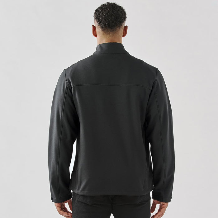 Men's Aleutian Softshell Jacket - A black men's softshell jacket with a high collar, featuring a logo on the back.