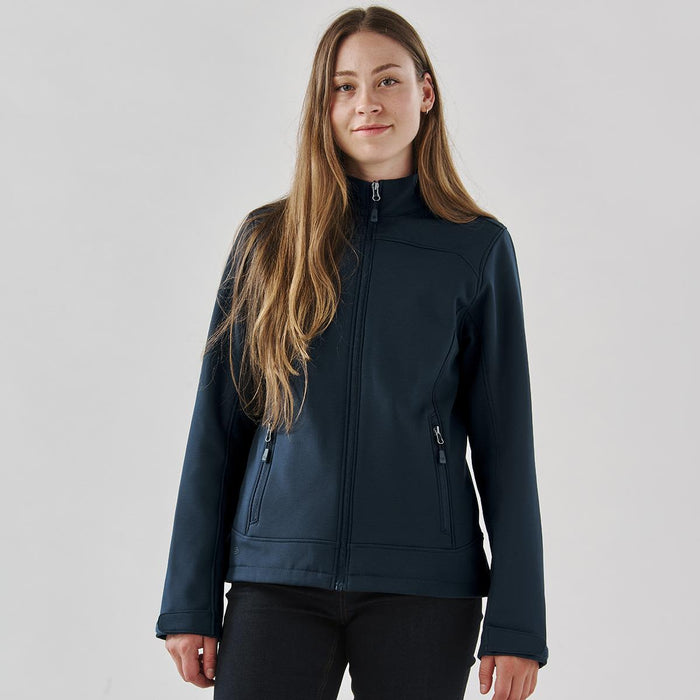 Women's Aleutian Softshell Jacket - A navy softshell jacket for women with a zippered front and two side pockets. It features a branding logo.
