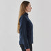 Women's Aleutian Softshell Jacket - A women's softshell jacket in navy blue, featuring a high collar and side zipper pockets. It has a logo on it.