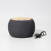 Boomer Bamboo Wireless Speaker - A round, grey wireless speaker with a wooden top and a USB cable beside it.
