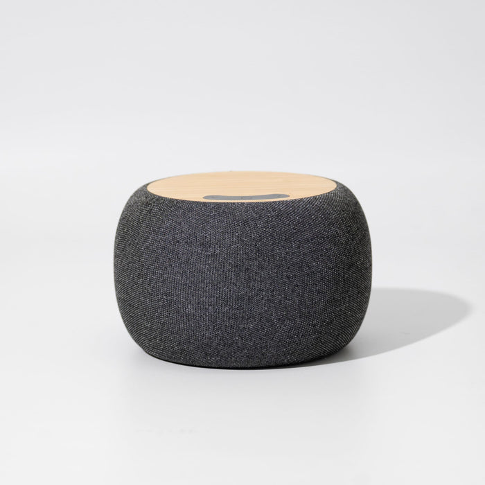 Boomer Bamboo Wireless Speaker - A round, grey wireless speaker with a wooden top surface and a logo on it.