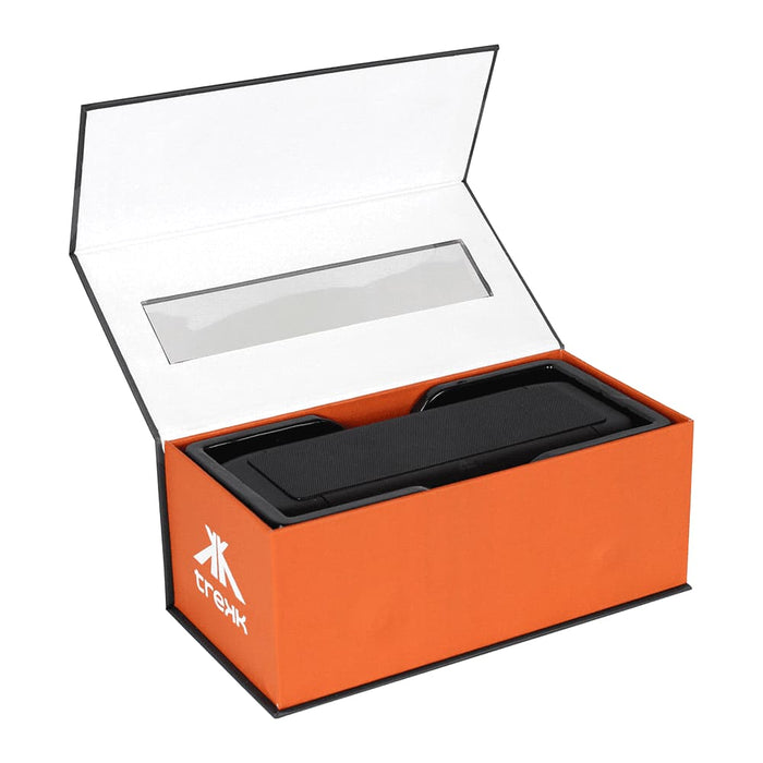 Trekk Outdoor Speaker & Wireless Powerbank - A black outdoor speaker and wireless power bank in an open orange box with a clear plastic window and branding.