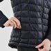 Women's Tundra Thermal Jacket - A women's puffer jacket in navy blue, featuring a quilted design and side zipper pockets. Includes branding.