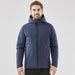 Men's Cascadia Thermal Jacket - A man wearing a navy blue puffer jacket with a hood, featuring a logo. The jacket has a zip closure and a fitted design.