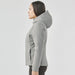 Women's Cascadia Thermal Jacket - A women's puffer jacket in grey with a hood, featured from the side view. Includes a branding logo.