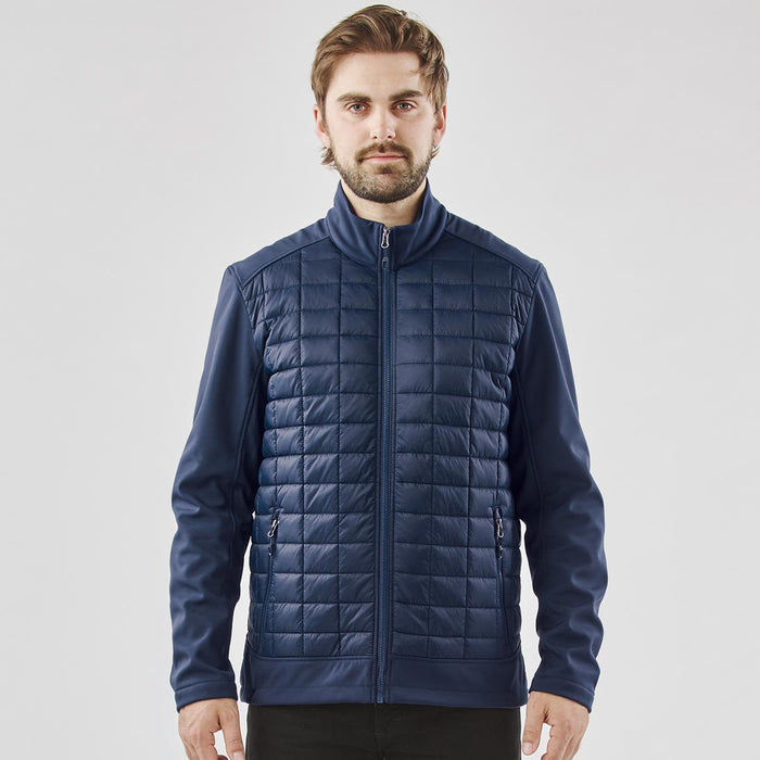 Men's Appalachian Thermal Softshell Jacket - A men's softshell jacket in navy blue featuring a quilted front and zippered pockets. The jacket includes a logo.
