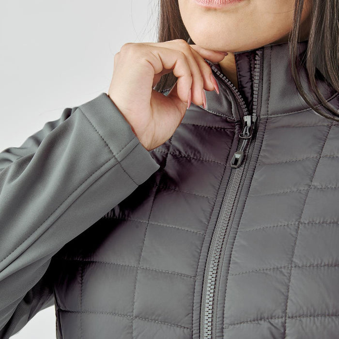 Women's Appalachian Thermal Softshell Jacket - A women's grey softshell jacket featuring a quilted design and a zippered front. It has a logo on the chest.