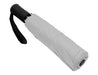 Como Fold-Up Umbrella - A fold-up umbrella in white with a black handle and a black strap for easy carrying.