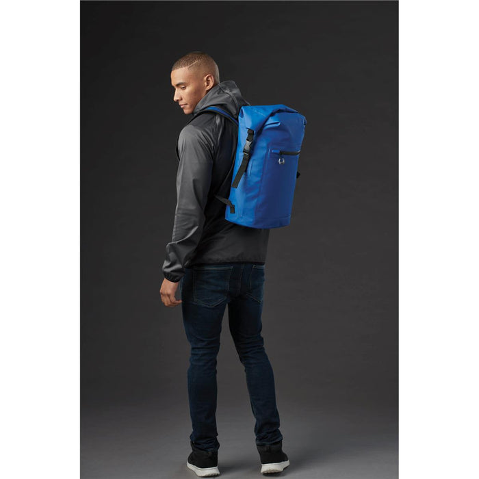 Cirrus Backpack - A man wearing a grey hoodie carries a blue Cirrus Backpack on his back. The backpack features a logo.
